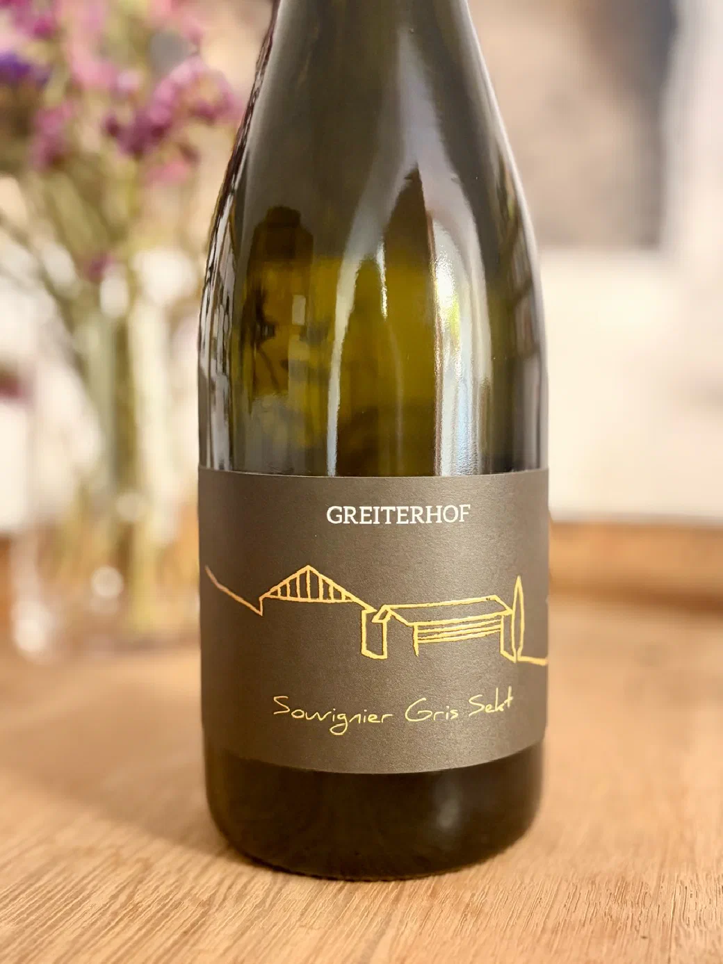 Flasche des Souvignier Gris Sekts vom Greiterhof mit dunklem Etikett