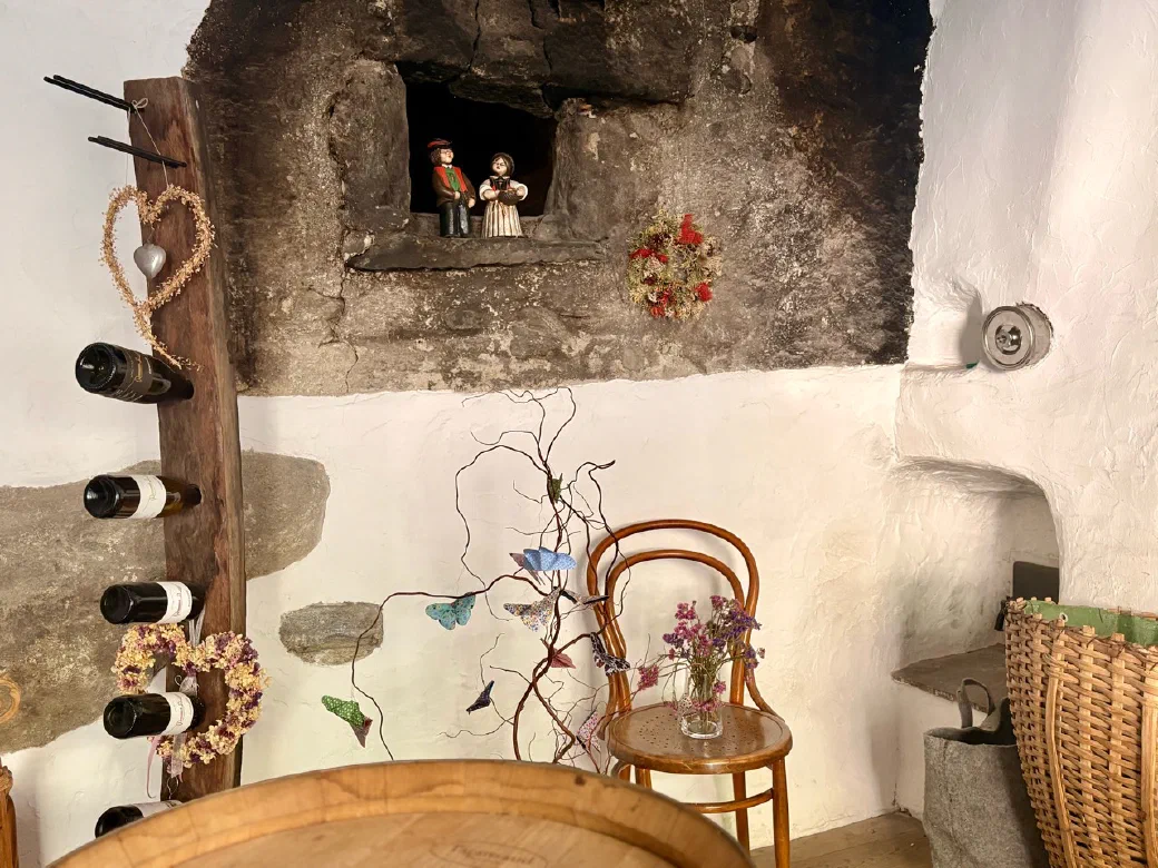 Weinflaschen und bäuerliche Details im historischen Hofladen des Greiterhofs